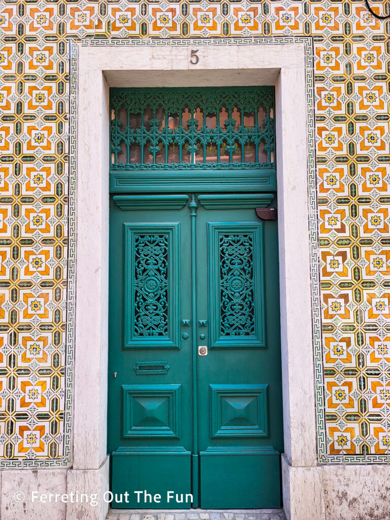 A pretty green door and orange tile building in Lisbon Portugal