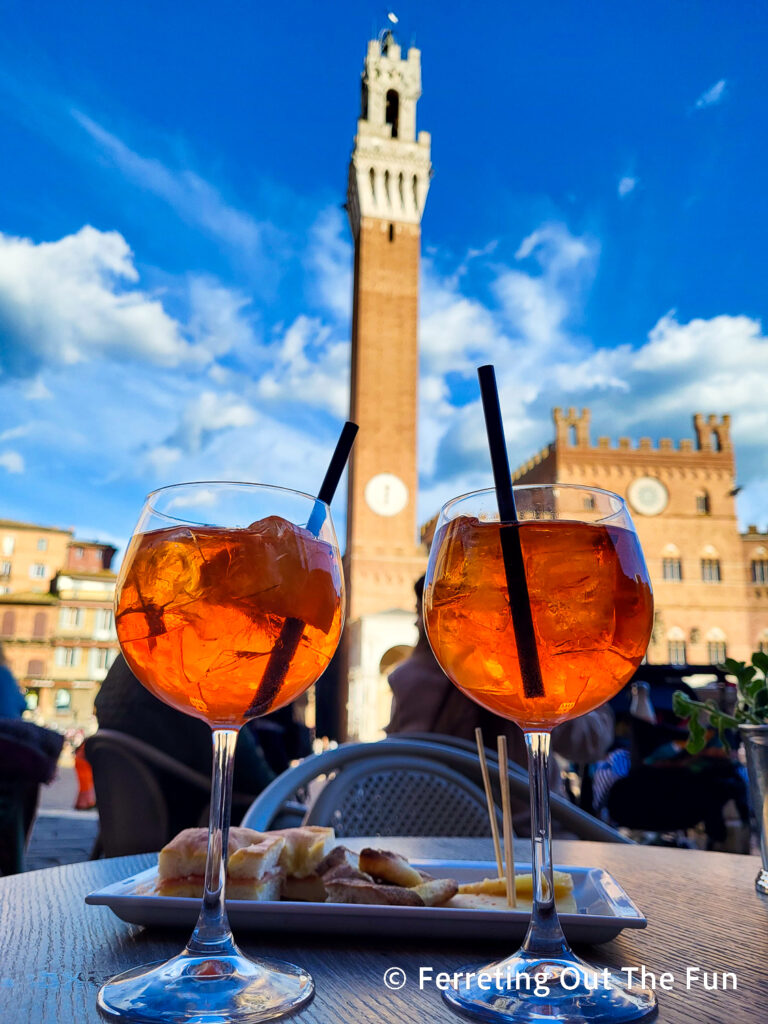 Enjoying Aperol Spritz in Il Campo, the main square in Siena Italy